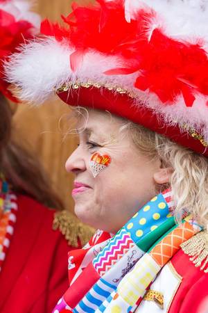 Karnevalsliebe: Frau beim Rosenmontagszug mit geschminktem Kölner Wappen als Herzsymbol auf der Wange