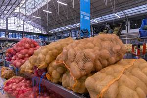 Kartoffeln und Zwiebeln in Säcken am Gemüsestand im Timeout Market in Lissabon