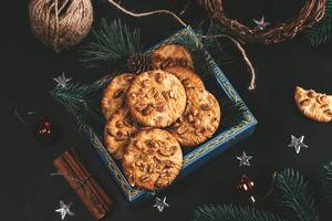 Kekse mit Erdnüseen in einer weihnachtlich dekorierten Schale mit Zimt, Tannenweigen und Sternen