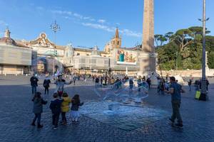 Kinder bewundern die riesigen Seifenblasen auf dem Piazza del Popolo in Rom