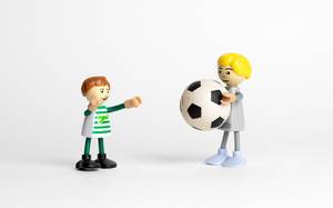 Kinder spielen mit einem Fußball - Modelfiguren