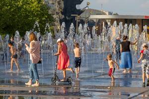 Kinder und ihre Mütter in einem Springbrunnen in Moskau
