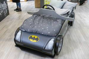Kinderbett in Form eines Batmobils mit Batman-Zeichen und Lenkrad in Möbelhaus