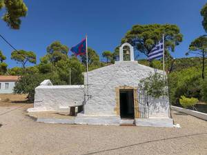 Kleine Kapelle mit Glocke, am Agii Anargiri Strand, mit wehenden Flaggen, auf der griechischen Insel Spetses