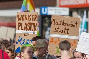 Klimaplakate "Weniger Plastik ist Meer" und "Plastikverbot statt Arten tot" umringt bei friedlichen jugendlichen Demonstranten