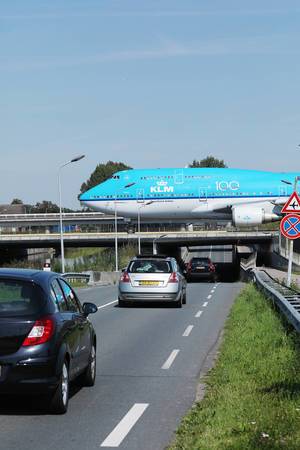 KLM B747 taxiing on the bridge over cars road at Amsterdam Airport