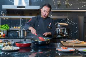 Kochshow mit asiatischer Küche: Professionelle Koch Martin Yan bei der Zubereitung eines asiatischen Gerichts