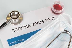 Konzeptbild mit Coronavirus Test, Stethoskop und Gesichtsmaske auf weißem Hintergrund