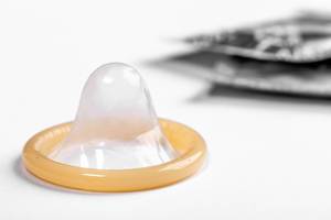 Konzeptbild zur Verhütung und sicherem Geschlechtsverkehr zeigt ein Kondom vor weißem Hintergrund