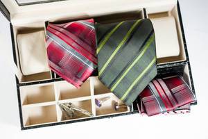 Krawatten, Manschettenknöpfe und Einstecktücher in einer Aufbewahrungsbox