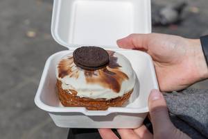 Kronut - Snack der "chök"-Bäckerei in der To-Go Verpackung, überzogen mit weißer Schokolade und einem Oreokeks, in Barcelona, Spanien
