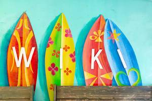 Kunstvolle Surfbretter mit der Aufschrift : WIKI an der Wand der WIKI Beach Strandbar auf Mallorca