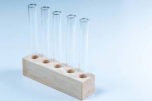 Labor Reagenzgläser in einem Holzständer vor bläulichem Hintergrund