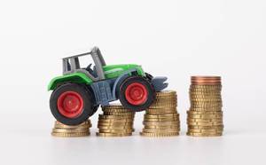 Landwirtschaft: ein Traktor auf vier Stapeln Münzen