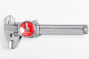 Längenmessgerät auf der Werkzeugkiste: Uhren-Messschieber vor weißem Hintergrund