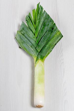Large leeks on a white wooden background. Top view (Flip 2019)