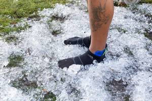 Läufer steht auf Eiswürfeln, um Füße zu kühlen