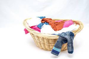 Laundry Basket with Clothes on a White Background