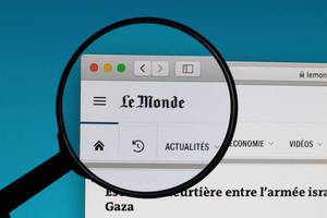 Le Monde logo under magnifying glass
