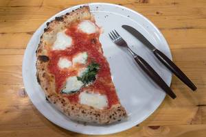Leckere Margherita Pizza auf einem Teller mit Messer und Gabel im 485 Grad Restaurant in Köln