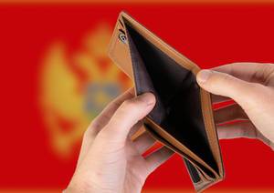 Leerer Geldbeutel aus Leder mit Flagge von Montenegro. Rezession und Finanzkrise werden mit mehr Schulden und Bundeshaushaltdefizit einhergehen
