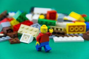 Lego Man running in front of Legos