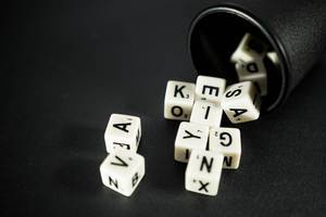 Letter dice coming out of a small black cup