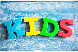 Letter magnets in chalkboard reading KIDS