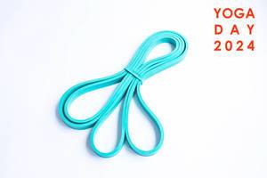 Light blue resistance band for gymnastics, on white background, next to title "yoga day 2024"