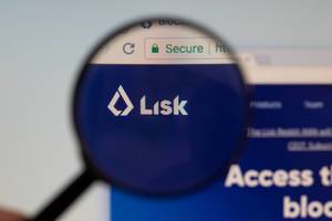 Lisk-Logo am PC-Monitor, durch eine Lupe fotografiert