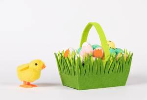Little chicken with basket full of Easter eggs