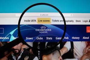 Logo der UEFA Champions League auf Internetseite hervorgehoben mit Lupe