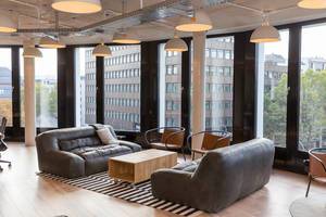 Lounge mit Sofas und großer Fensterfront mit Blick über Köln, vom Coworking-Büro WeWork
