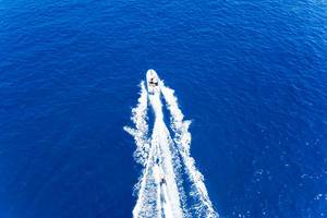Luftaufnahme der Wassersportart Wasserski, hinter einem Schnellboot, auf dem Myrtoischen Meer