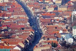 Luftaufnahme einer Straße und Häuserdächern der Großstadt Brasov in Rumänien