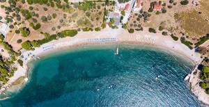 Luftaufnahme mit Sicht auf den Strand Paralia Agii Anargiri, in einer Bucht mit klarem grünem Wasser des Mystischen Meeres, in Griechenland