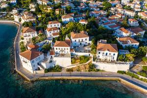 Luftbild der Küstenstraße auf der malerischen Insel Spetses, vor aristokratischen, neoklassizistische Wohnhäusern, im Argolischen Golf