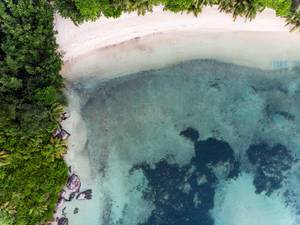 Luftbild der Strandabschnitte Port Glaud und Port Launay Süd mit kristallklarem Wasser des Indischen Ozeans auf der Seychellen-Insel Mahé