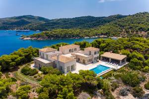 Luftbild einer mehrstöckigen Villa mit privatem Pool und Gartenanlage, umgeben von wilder Natur, auf der griechischen Urlaubsinsel Spetses
