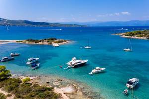 Luftbild von teuren Yachten und Urlaubern auf Motorsportbooten im blauen Meer des Argolischen Golfs vor Ermionida, Griechenland