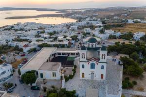 Luftbild zeigt die farbenfrohe Hauptkirche der wunderschönen Hafenstadt Naoussa auf Paros, Griechenland