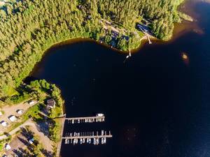 Luftbild zeigt Ferienhäuser Kiuasniemi Villas, Villa Paapuuri und Villa Jolla & das Ufer von Padasjoki, am großen See Päijänne mit Booten im kleinen Hafen