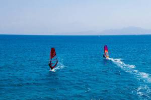 Luftbild zeigt zwei Windsurfer auf dem blauen Meer vor Paros, Griechenland, in der Ägäis