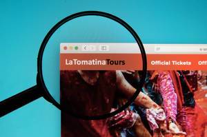 Lupe hebt Logo von La Tomatina Tours auf Internetseite hervor