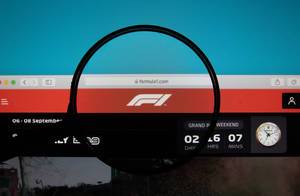 Lupe über dem Formel-1-Logo der Internetseite von Formula 1