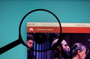 Lupe über dem Logo der Internetseite der Biennale di Venezia