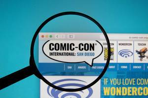 Lupe über dem Logo der Internetseite der Comic-Con International: San Diego