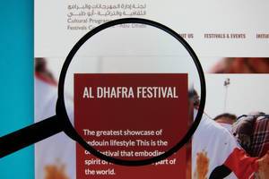 Lupe über dem Logo der Internetseite des Al Dhafra Festivals