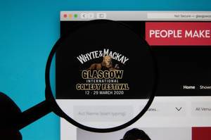 Lupe über dem Logo der Internetseite des Glasgow International Comedy Festivals 2020