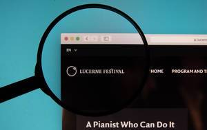Lupe über dem Logo der Internetseite des Lucerne Festival